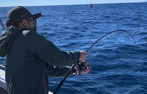 Риболов на океан с Offshore морски въдици DAIWA OUTRAGE, мъж на лодка, хващане на риба в морето.