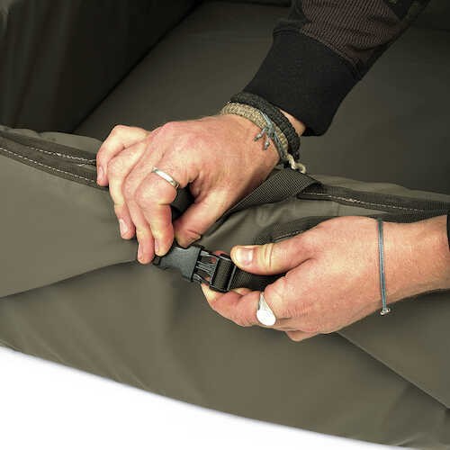 Hands adjusting the buckle on the Карп люлка AVID Folda Cradle - Standard/XL for secure use.