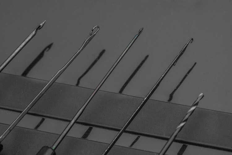 Комплект игли KORUM TI - BAITING NEEDLE SET показва различни игли на черен фон.