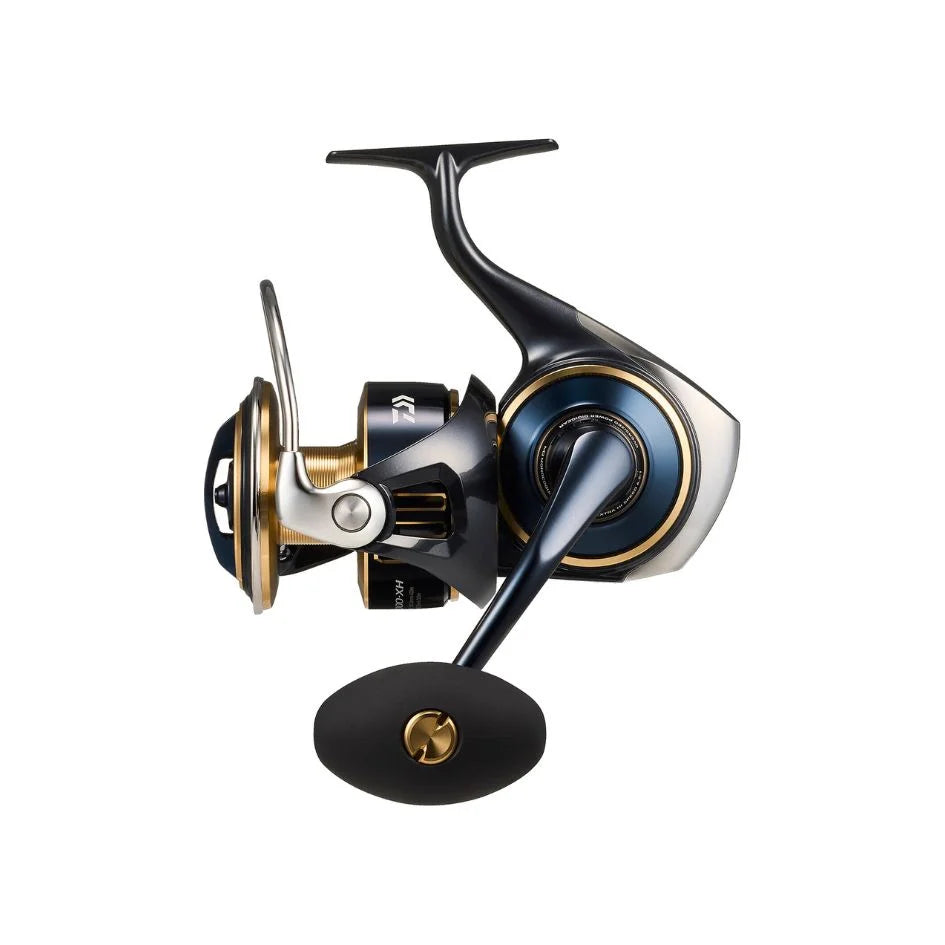 Морска макара Daiwa 25 Saltiga G с тъмно тяло, златиста шпула, метален бигел и черна ръкохватка, показана отстрани.