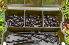 Бързи връзки KORUM Camo Quick Change Bead - S/L in a storage box, showcasing various fishing accessories.