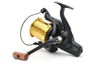 Шаранджийска макара DAIWA 23 EMBLEM 45 SCW QD-OT с златиста шпула и ергономична дръжка.