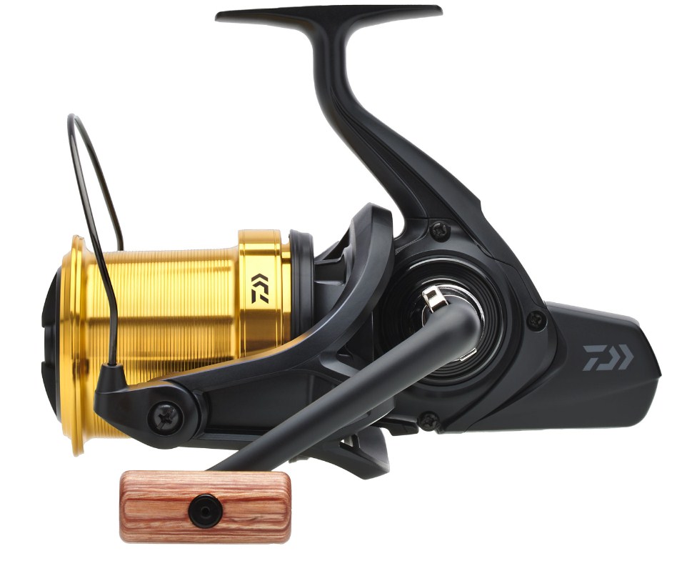 Шаранджийска макара DAIWA 23 EMBLEM 45 SCW QD-OT с черно-златна конструкция и дървена ръкохватка.
