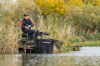 Риболов на платформата DAIWA D500SB - D36 в природата, рибар с въдица край водата и храстите.