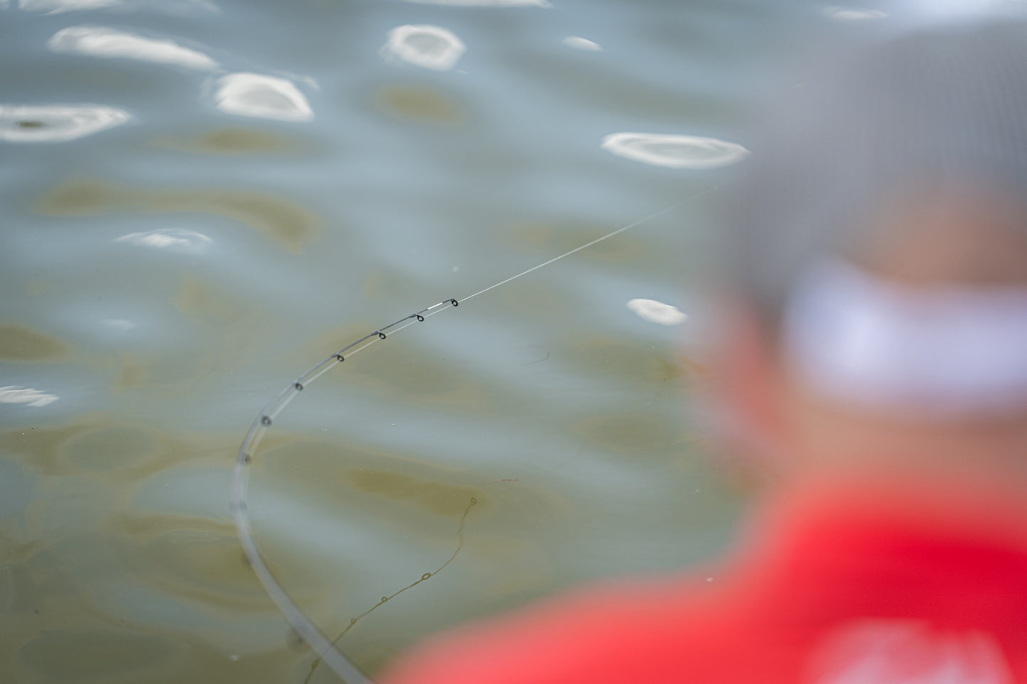 Фидер въдици DAIWA TOURNAMENT SLR - New model 2025 на водата с рибар, готов за риболов.
