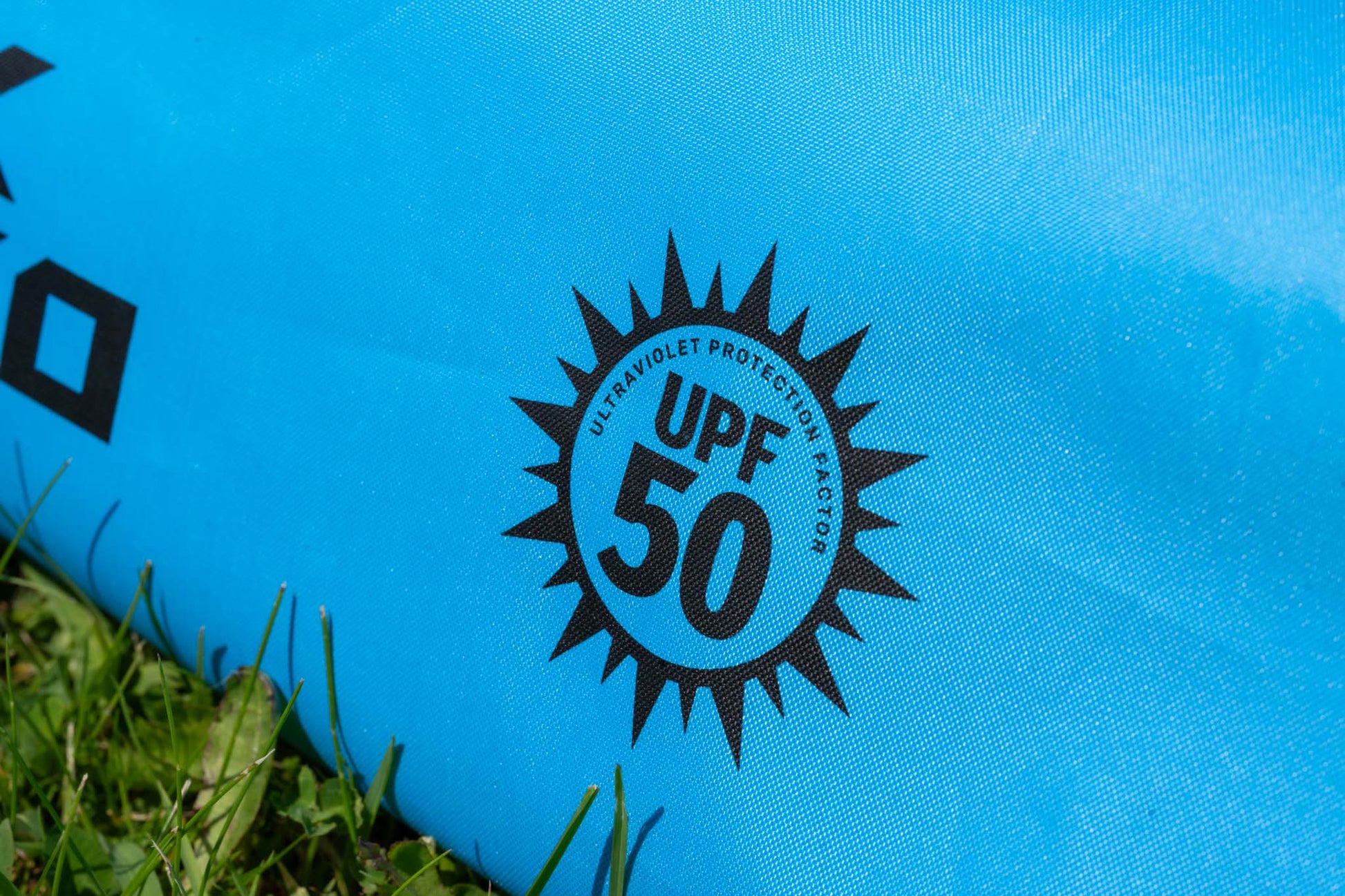 Чадър PRESTON COOLMAX 50" BROLLY with UPF 50 ultraviolet protection marking close-up on a blue background.