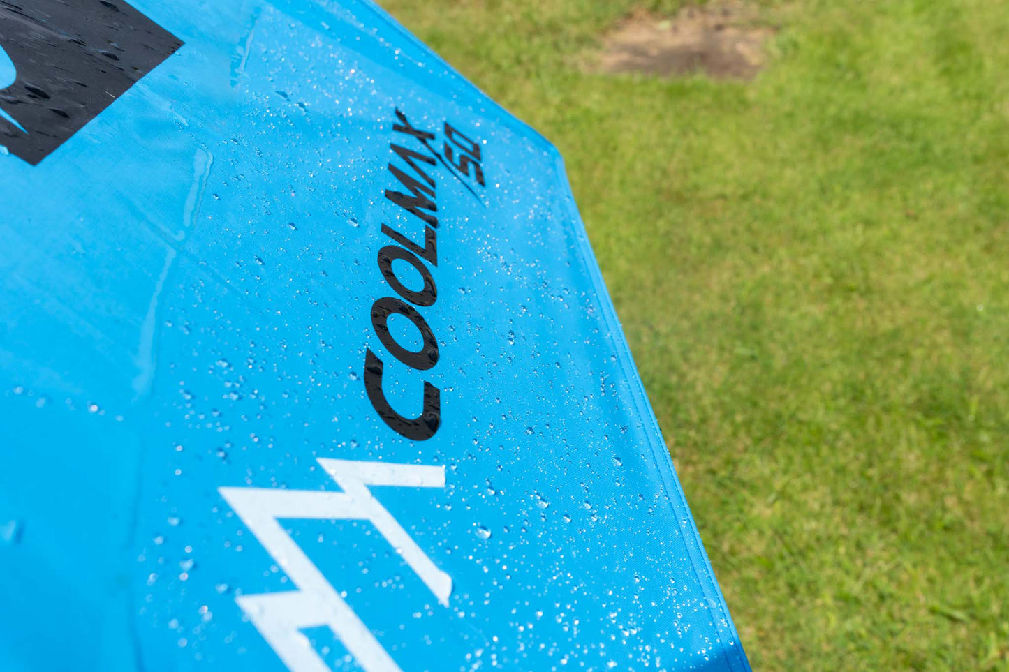 Чадър PRESTON COOLMAX 50" BROLLY with water droplets on its vibrant blue fabric.