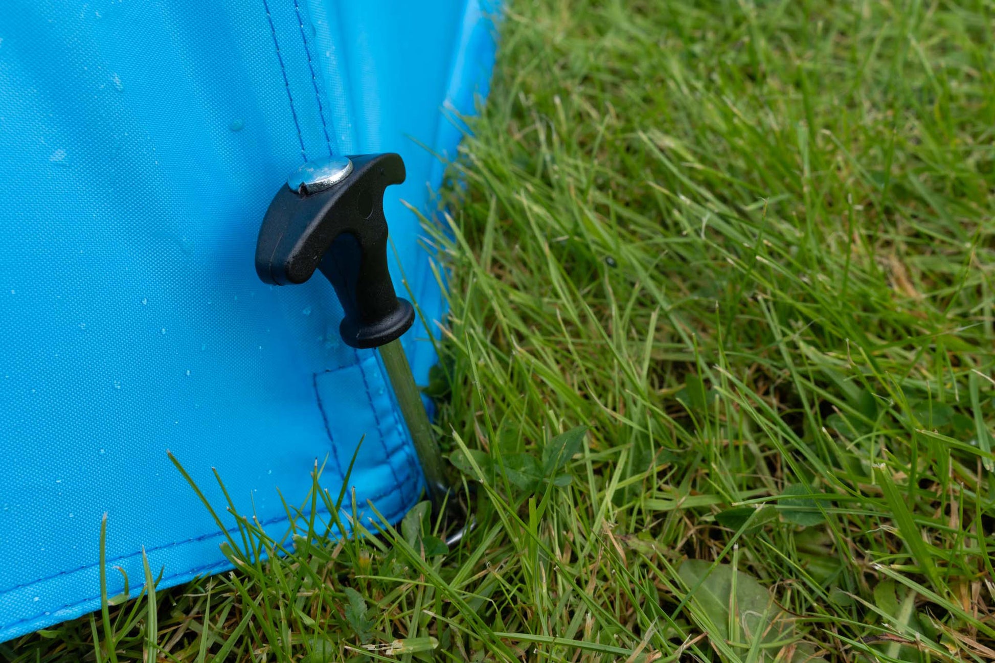 Чадър PRESTON COOLMAX 50" BROLLY secured with a stake in grassy area for stability.