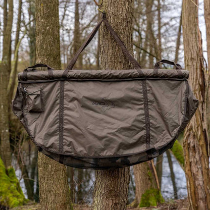 Карп сак - AVID PRO-TECT FLOTATION SLING, запазен на дърво, идеален за безопасно съхранение на риби.
