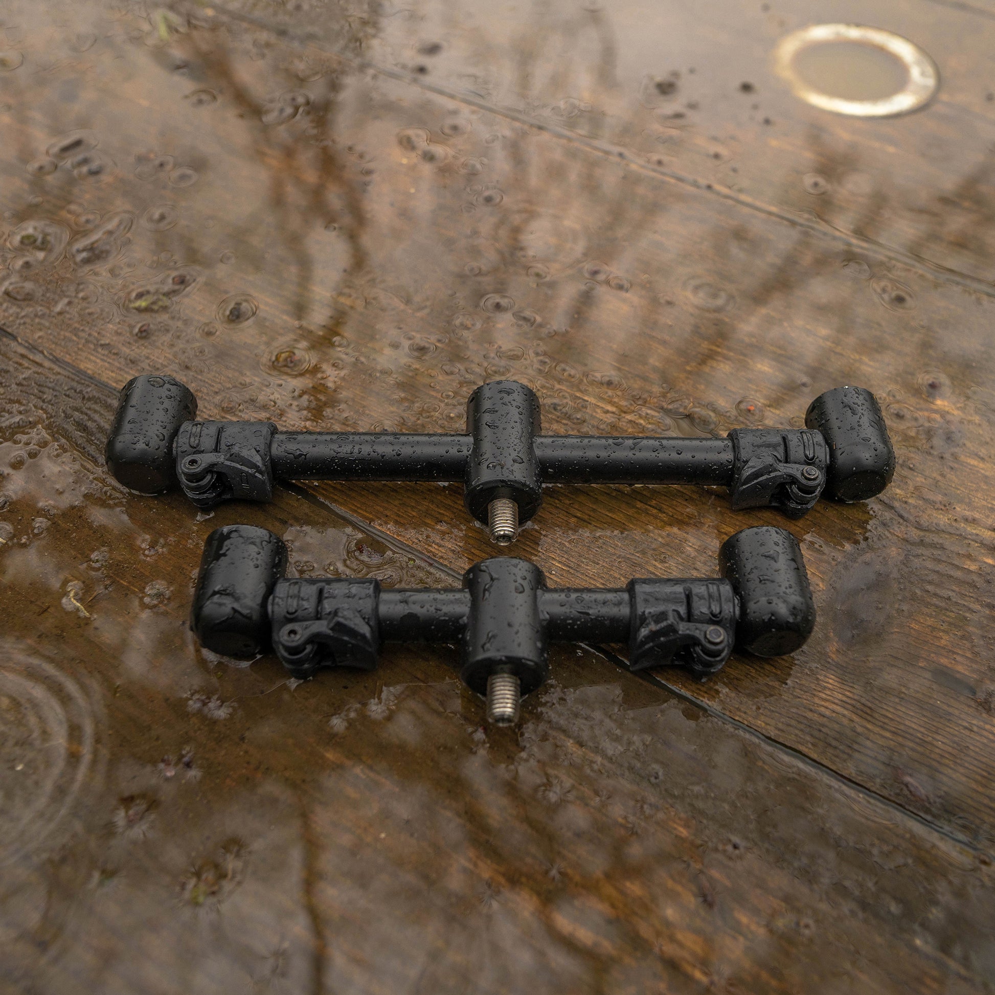 Регулируема стойка за 2 въдици AVID Lok Down Adjustable Buzz Bar на дъска, покрита с капчици вода.