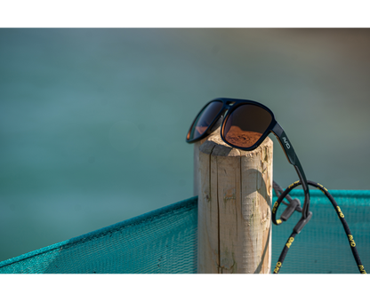 Поляризирани слънчеви очила AVID CARP SeeThru AV Classic Polarised Sunglasses поставени на дървено стълбче