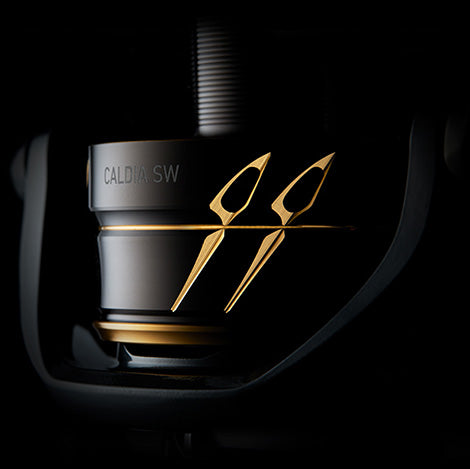 Макара Daiwa 22 CALDIA SW (JP) в черен фон с златни детайли.