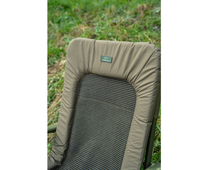 Луксозен фидер стол KORUM Supa Lite Stretch - Deluxe Chair с удобна и устойчива облегалка на тревиста поляна.