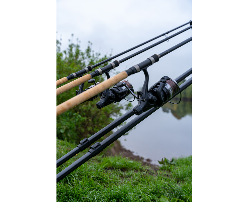 Родпод Korum DELUXE 3 ROD TRIPOD с три въдици и ролки на фон на река.