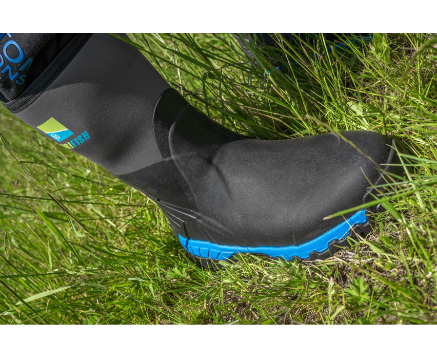 Ботуши PRESTON Drifish Boots на крака, с черен и син дизайн, разположени на зелена трева.