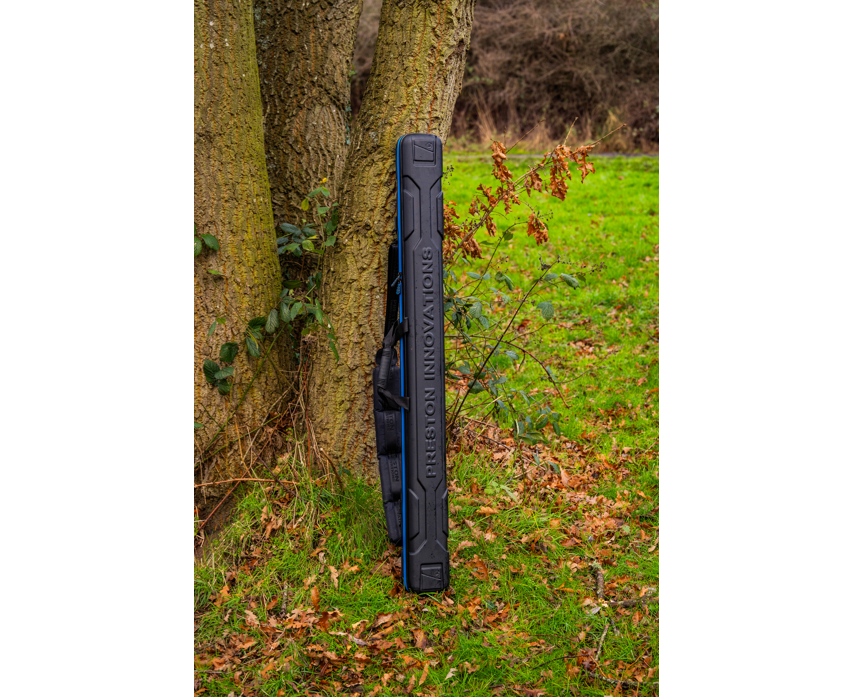 Твърд калъф PRESTON HARDCASE COMPACT KIT SAFE leaning against a tree in a natural setting.