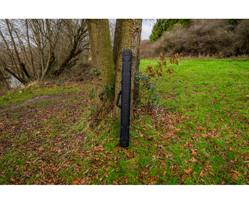 Твърд калъф PRESTON HARDCASE COMPACT KIT SAFE leaning against a tree in a natural outdoor setting.