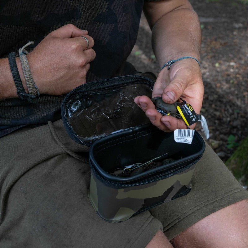 Чанта AVID STORMSHIELD PRO POUCH being used outdoors with a hand holding fishing tackle.