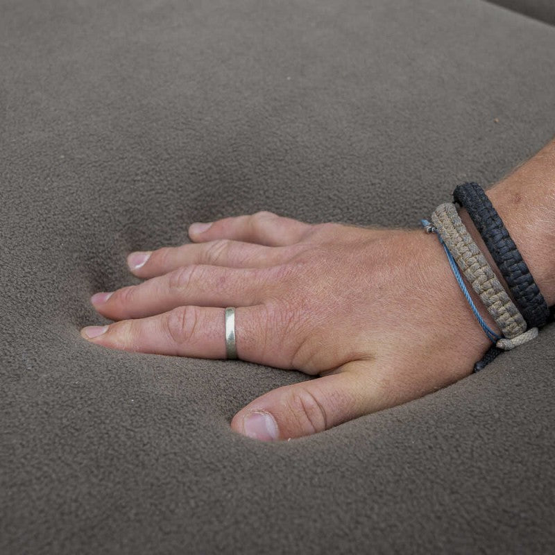 Легло - AVID CARP Benchmark LevelTech Bed with a hand resting on the soft surface.