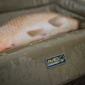 Карп люлка AVID CARP Stormshield Safeguard Cradle - Standard on a wet surface with a fish.