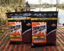 Пелети Dynamite Baits PRO Expanders - RED KRILL packaging by the water, perfect for carp fishing.