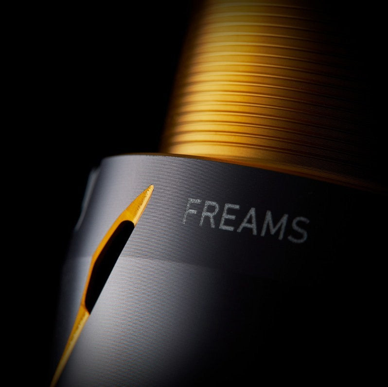 Спинингова макара - DAIWA 21 FREAMS LT - детайл от дизайна с логото FREAMS и златисто шампанско.