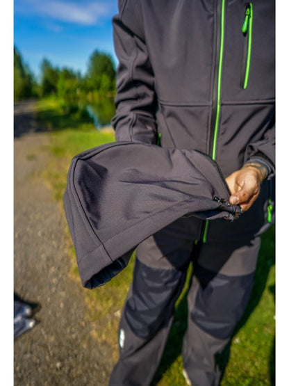 Мъж в яке MAVER PERFORMANCE SOFTSHELL JACKET държи ръкав от якето, показвайки детайли и качество на материала.
