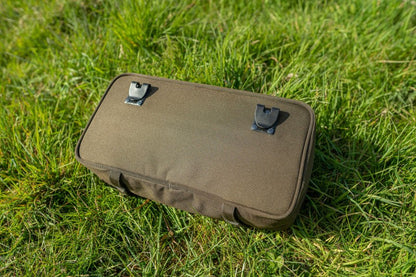 Чанта AVID Compound Pouch върху зелена трева с клик-система за прикрепване на аксесоари.