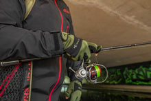 Неопренови ръкавици KORUM Neoteric Gloves на ръката на рибар, държащ въдица и макара под мост.