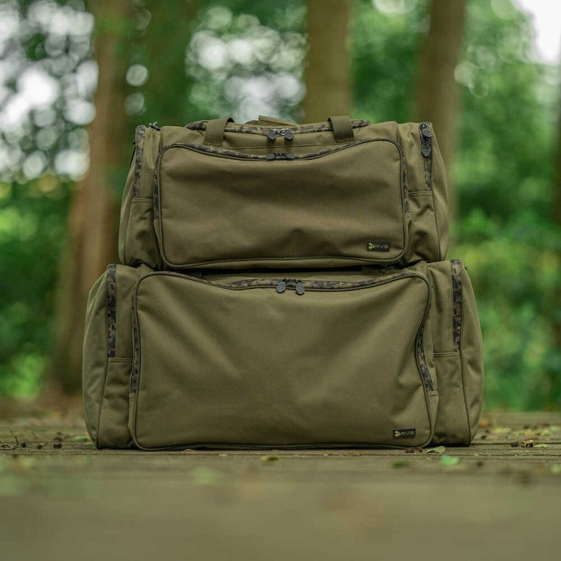 Сак AVID RVS CARRYALL - MEDIUM displayed in a natural outdoor setting with two bags stacked.