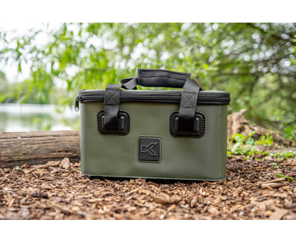 Комплект футери и сито KORUM EVA TACKLE & BAIT STATION displayed in natural setting beside a log.