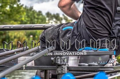Прикачно PRESTON OFFBOX EXTENDING GRIPPER ROOST mounted on fishing gear by a angler on a boat.