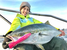 Попер DAIWA SALTIGA POP STAR 160F GALAXY ORANGE - 16cm/74gr with a fisherman holding a large fish.