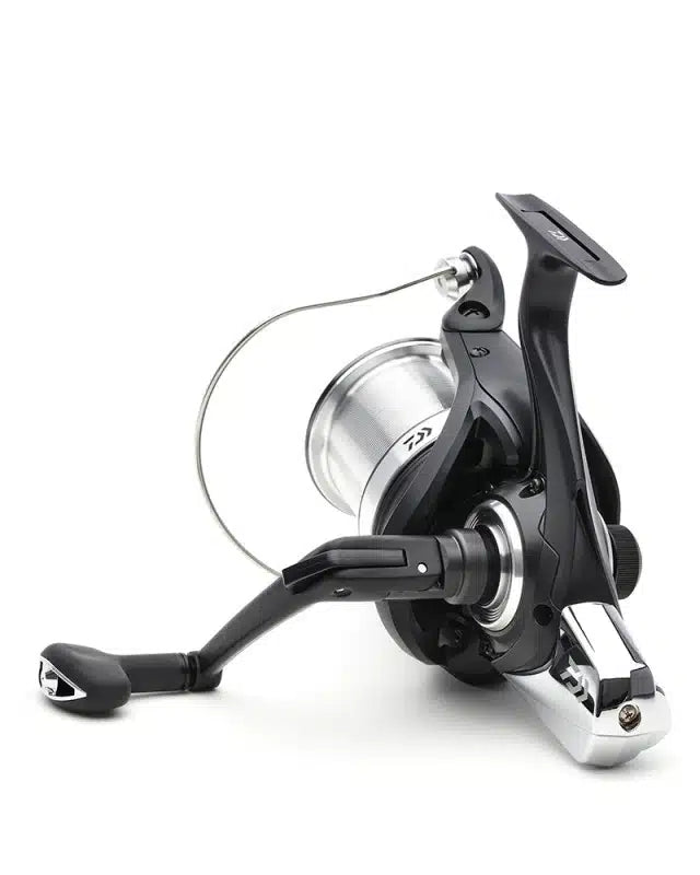 Шаранджийска макара DAIWA 23 SUPERSPOD 45 SCW QD OT с черно-сребрист дизайн и здрава конструкция.